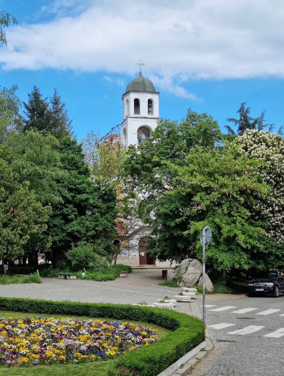 Църква с камбанария сред зеленина в Гоце Делчев